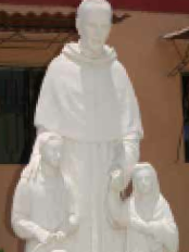A statue of Father Edward Chapman, O.S.A., with two children stands outside the Augustinian friary in Morropón, Peru. 